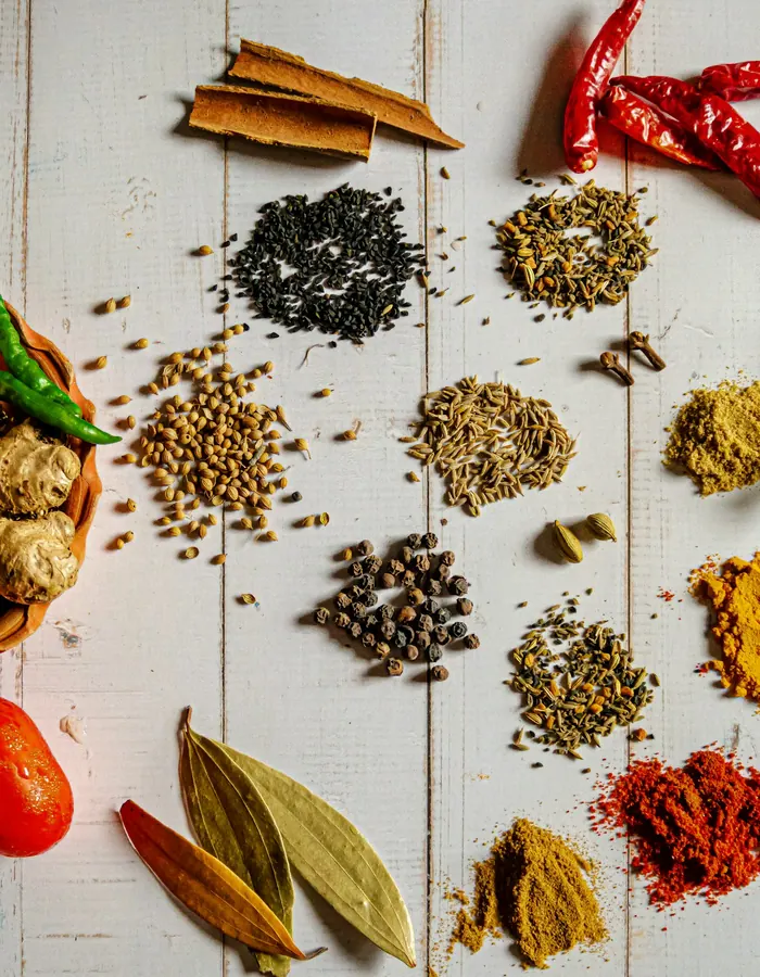 Whole and ground spices laid out on a white board